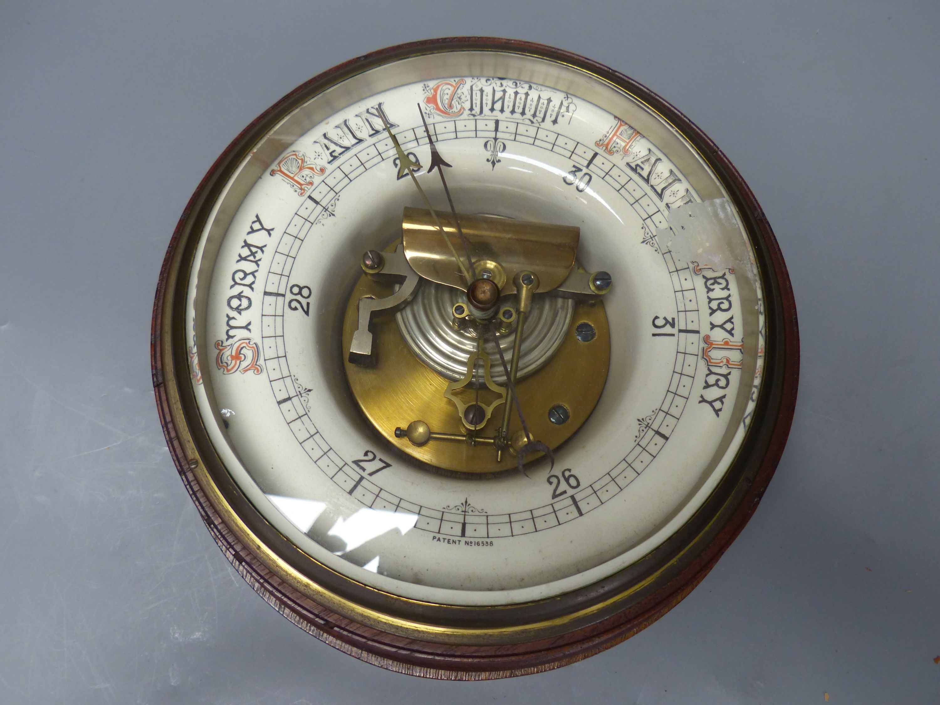 A circular wall mounted aneroid barometer, diameter 25cm
